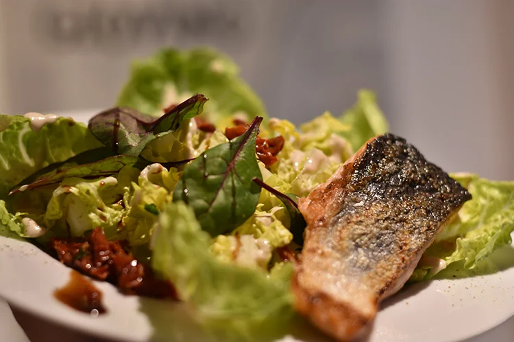 Das Restaurant Giovino serviert einen knackigen Salat mit frischem Lachs, welcher schön angerichtet ist.